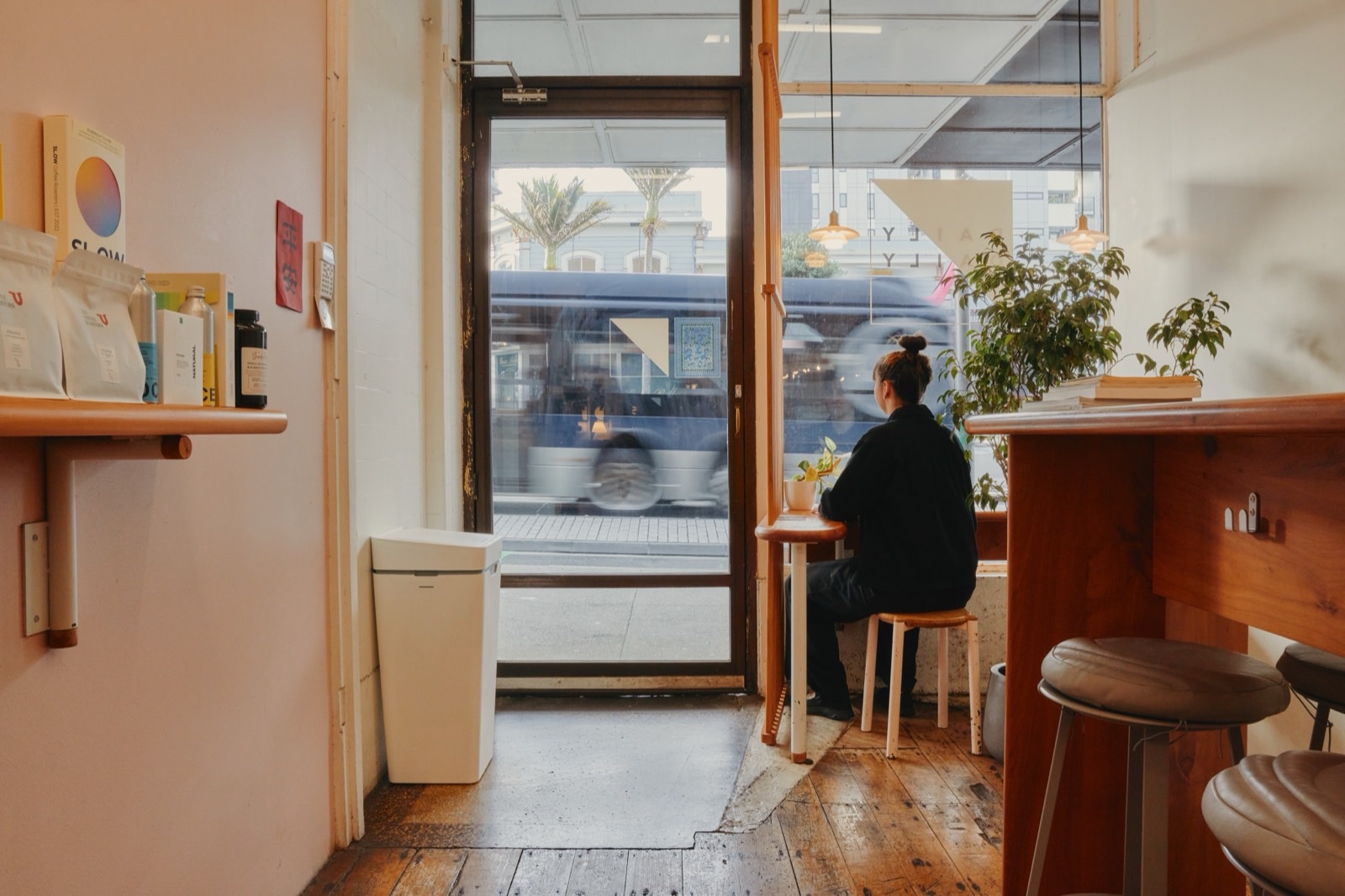 A white Mono by a café’s front door as a customer sits at the window